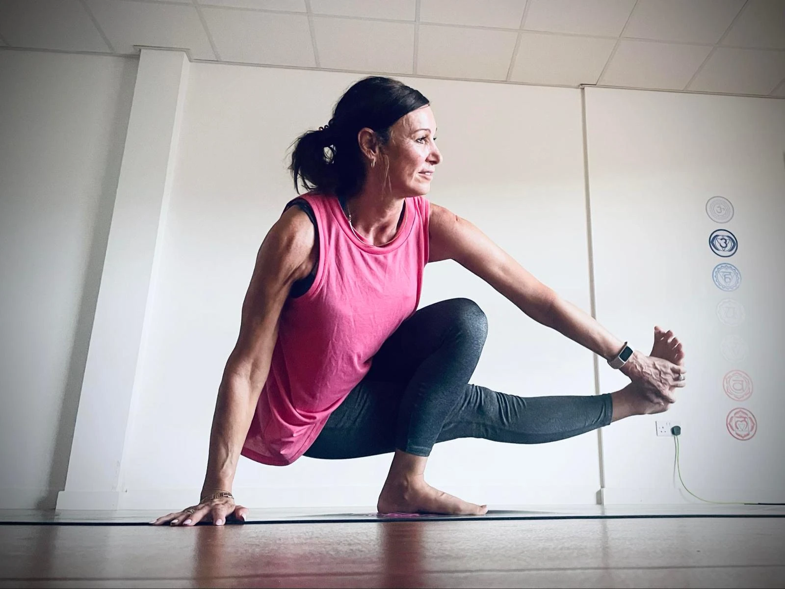 Anna balancing in a yoga pose in the studio